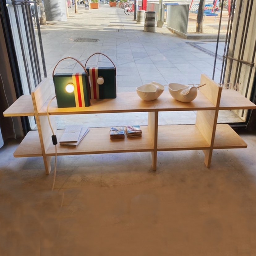 Escritorio de madera de caballete con silla de contrachapado curvado, jarrón con flores secas y lámpara, bajo luz natural